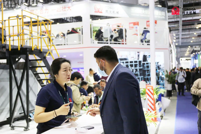 Représentant Tongda échangeant avec un visiteur à CHINAPLAS 2024
